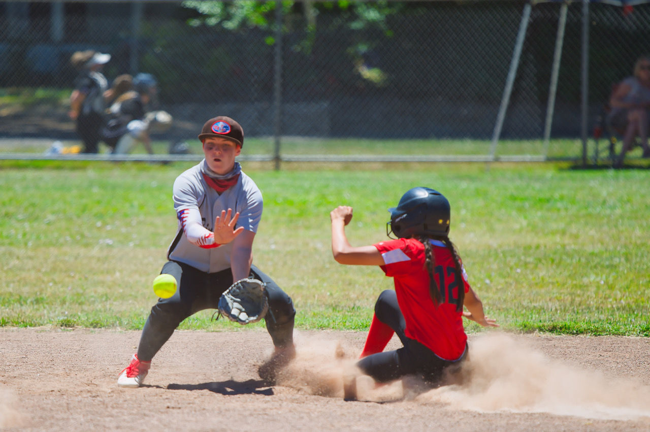 Binstock Enterprise's Noleen Cichon waits for the throw as Soscol Auto Body's Desiree Griffith slides